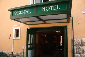a hotel with a green sign over the door at Hotel Kristal in Budapest