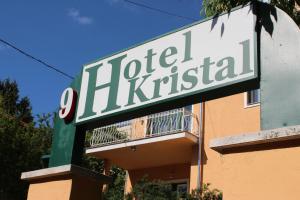 ein Schild für ein Hotel vor einem Gebäude in der Unterkunft Hotel Kristal in Budapest