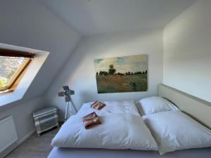 a bedroom with a white bed with a painting on the wall at 2 Zimmer Appartement in Borgholzhausen