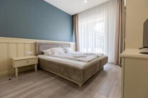 - une chambre dotée d'un lit avec un mur bleu dans l'établissement Degenfeld Kastély Tóparti Vendégház, à Téglás