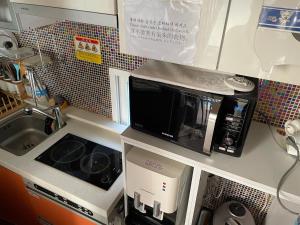 a kitchen counter with a microwave and a coffee maker at Chloe Hostel in Seoul