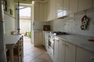 Spaziosa casa con giardino e dependance في فياريجيو: مطبخ بدولاب بيضاء وقمة كونتر