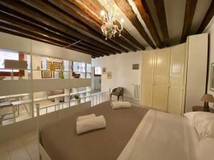 een grote slaapkamer met een groot bed en een kroonluchter bij Ca Molin by Venicevillas, vista canale in Venetië