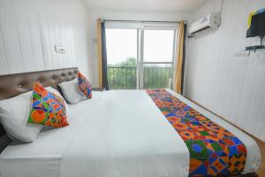 een slaapkamer met een groot bed en een raam bij FabExpress Vincy Palace, Mandrem Beach in Arambol