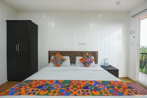 een slaapkamer met een groot bed en een kleurrijke quilt bij FabExpress Vincy Palace, Mandrem Beach in Arambol
