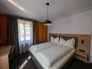 菲利苏尔Hotel Restaurant Rätia的卧室里有一张白色的大床，床边有一扇窗户