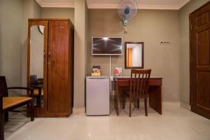 cocina con escritorio, nevera y silla en Van Giao Hotel, en Ho Chi Minh