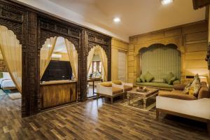 ein Wohnzimmer mit einem Sofa und einem TV in der Unterkunft Hotel Grand Khalifa in Jaisalmer
