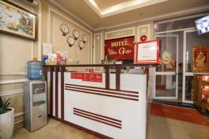 un mostrador de hotel en un restaurante con relojes en la pared en Van Giao Hotel, en Ho Chi Minh