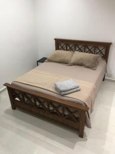 1 cama con marco de madera y almohadas en Wawa Estudio en Posadas