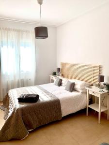 a bedroom with a large bed with a desk and a window at Casa Benks - Mar Menor Golf in Torre-Pacheco