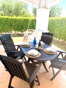 a blue table with chairs and a bottle of wine at Casa Benks - Mar Menor Golf in Torre-Pacheco