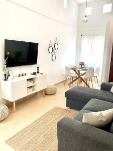 a living room with a tv and a couch and a table at Casa Benks - Mar Menor Golf in Torre-Pacheco