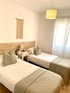 a hotel room with two beds and a table at Casa Benks - Mar Menor Golf in Torre-Pacheco