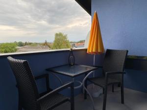 a table and chairs on a balcony with an orange umbrella at The blue House Sylvia in Gols