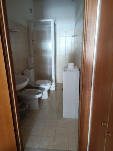 ein Badezimmer mit 2 WCs und einem Waschbecken in der Unterkunft Acqua Cristallina in Arenella