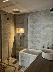 a bathroom with a bath tub and a sink at Appartement 180 degrés de rêve à Jongny in Jongny