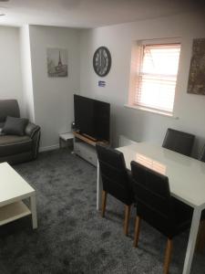 a living room with a tv and a table and chairs at Beautiful 2 bed apartment with Parking and Wifi and 3 Smart TV's in Great Oakley