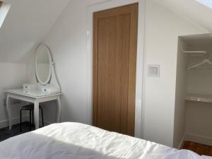 a bedroom with a bed and a sink and a mirror at Fig Cottage Holiday Home in Whitecroft