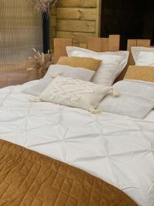 a large bed with white sheets and pillows at Cabane au style scandinave et son bain nordique in Bouillon