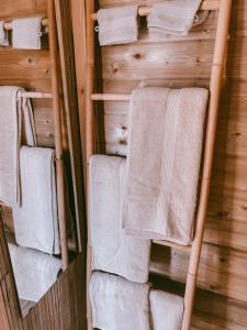 un toallero con toallas blancas. en Cabane au style scandinave et son bain nordique en Bouillon