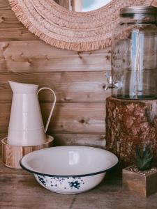 una ciotola e un vaso seduti su un tavolo di Cabane au style scandinave et son bain nordique a Bouillon