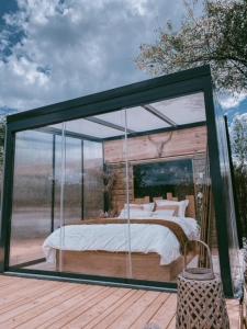 una camera in vetro con un letto all'interno di Cabane au style scandinave et son bain nordique a Bouillon
