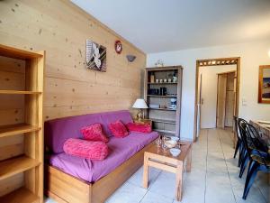 ein Wohnzimmer mit einem lila Sofa und einem Tisch in der Unterkunft Appartement Les Menuires, 3 pièces, 6 personnes - FR-1-344-767 in Les Menuires