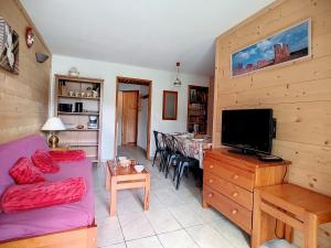 ein Wohnzimmer mit einem Sofa, einem TV und einem Tisch in der Unterkunft Appartement Les Menuires, 3 pièces, 6 personnes - FR-1-344-767 in Les Menuires