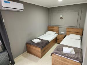 a small room with two beds and a air conditioner at Hotel Rose in Tbilisi City