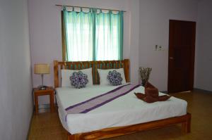 una camera da letto con un letto grande con una grande finestra di Lanta Ala Guest House a Phra Ae beach Altre 18 foto