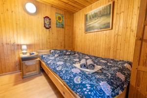 een slaapkamer met een bed in een houten kamer bij Domek Całoroczny Jaśkowa Chata Leleszki 30 dom 4 in Leleszki