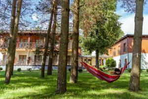 a man sleeping in a hammock in front of a building at Regina in Druskininkai