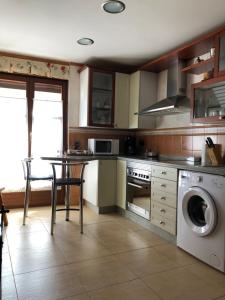 a kitchen with a table and a washing machine at Casa Mino in Mansilla de las Mulas
