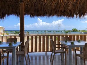 two tables and chairs on a deck with a view of the ocean at Punta Rucia Cristal Beach in Punta Rucia