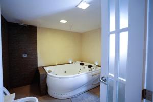een badkamer met een wit bad in een kamer bij Depar de lujo duplex familiar con Jaccuzi in Cuenca