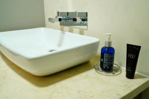 a white sink and a bottle of soap on a counter at Depar de lujo duplex familiar con Jaccuzi in Cuenca