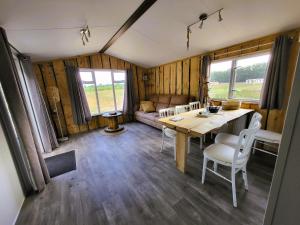 a dining room and living room in a tiny house at Hoeve Twente - De Buizerd in Heythuysen