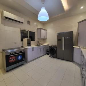 a large kitchen with a stove and a refrigerator at Jamal Royal Apartments in Medina