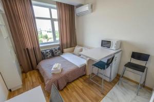 a small room with a bed and a desk with a microwave at Smart House 11 in Kyiv