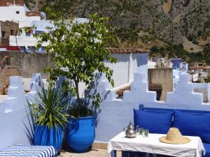 a blue and white room with a white table and chairs at Dar Zambra in Chefchaouen