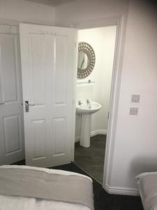 baño blanco con lavabo y puerta blanca en Beautiful 2 bed apartment with Parking and Wifi and 3 Smart TV's en Great Oakley