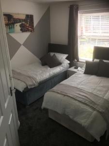 Rúm í herbergi á Beautiful 2 bed apartment with Parking and Wifi and 3 Smart TV's