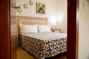 a bedroom with a bed with a black and white comforter at Apartamento Poleo in Icod de los Vinos