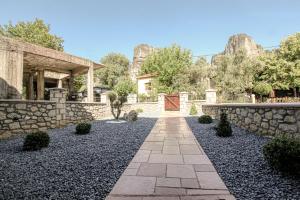 a garden with a stone wall and a walkway at Meteora Heaven and Earth Kastraki premium suites - Adults Friendly in Kalabaka
