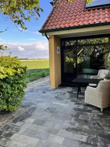 a house with a patio with a table and chairs at B&B de Danser in Klaaswaal