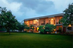 a building with a lawn in front of it at Kalangan Farms By Spicy Mango in Alibaug