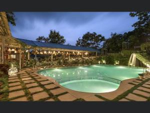 a large swimming pool in front of a building at Kalangan Farms By Spicy Mango in Alibaug