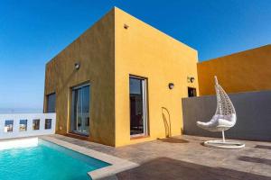 a house with a swimming pool next to a building at Villa Horizon in Caleta De Fuste