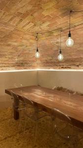 a wooden table with two chairs and three lights at La casa di mezzo in Calascio